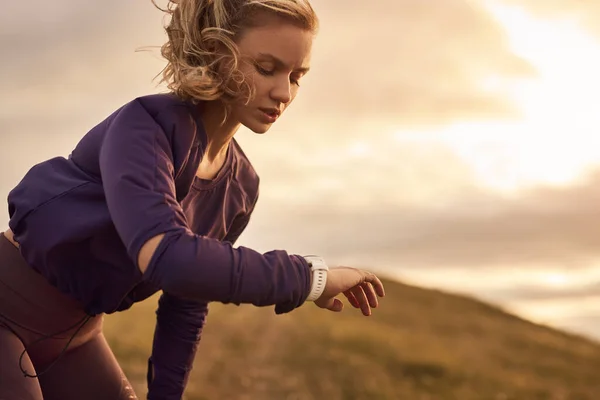 Kadın koşucu kol saati üzerindeki zamanı kontrol ediyor — Stok fotoğraf
