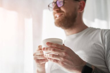 Neşeli adam sabahları kahve içiyor.