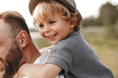 Baba doğadaki çocuğu sırtında taşıyor.