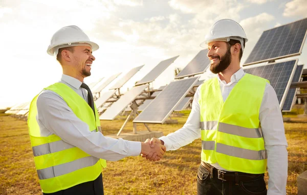 İş ortakları güneş panelleriyle sahada el sıkışıyor — Stok fotoğraf