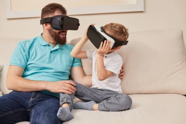 Baba ve oğul sanal gerçekliği sanal gözlüklerle keşfediyorlar.