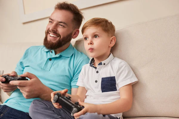 Pai e filho jogando videogame em casa — Fotografia de Stock