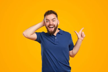 Şaşırmış bir adam kenarı gösteriyor ve kafaya dokunuyor