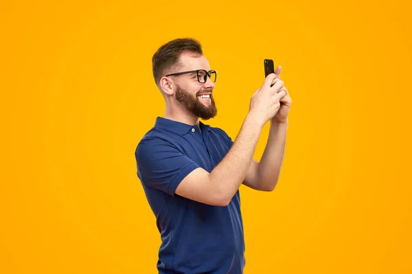 Hombre alegre tomando fotos a través de un teléfono inteligente —  Fotos de Stock