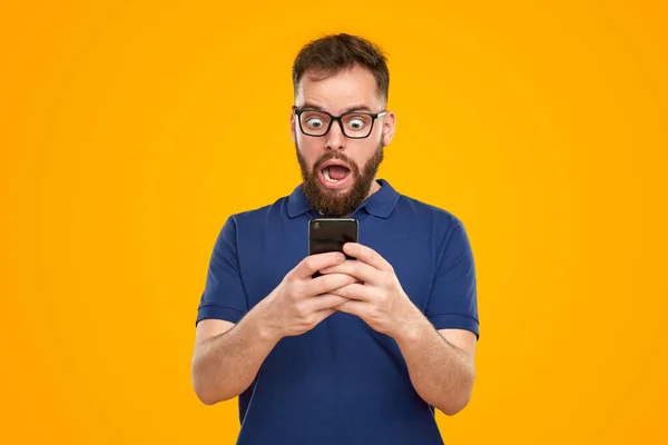 Homem surpreso lendo notícias no smartphone — Fotografia de Stock