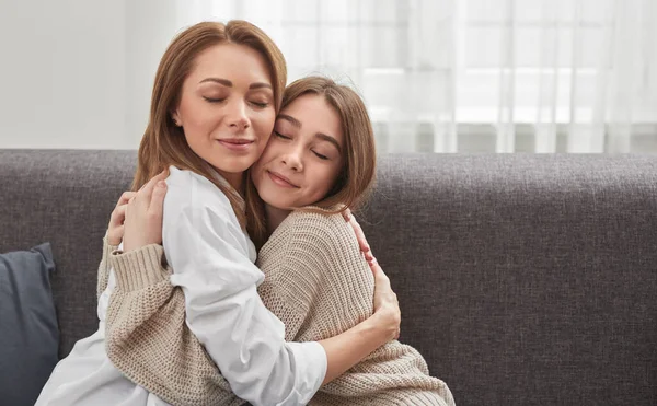 Inhoud moeder en dochter knuffelen thuis — Stockfoto