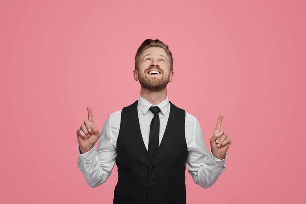 在粉红背景的广告宣传活动中 身穿白衬衫和黑色背心的快乐的男性创业者微笑着看着对方 — 图库照片