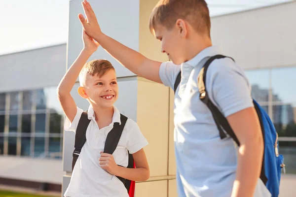 Gelukkige klasgenoten geven high five aan elkaar — Stockfoto