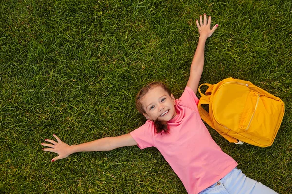 Lachende leerling liggend op gras in het park — Stockfoto