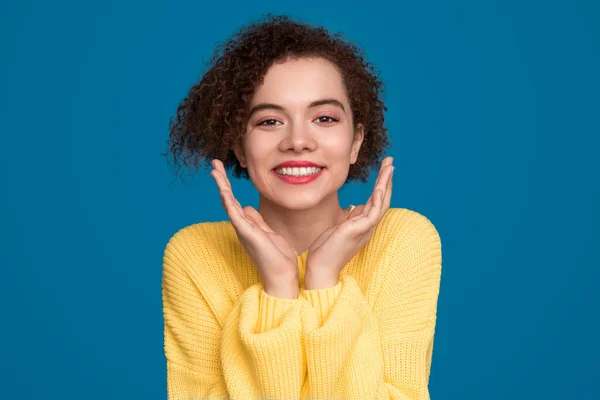 Mujer encantadora con las manos cerca de la cara en el estudio — Foto de Stock