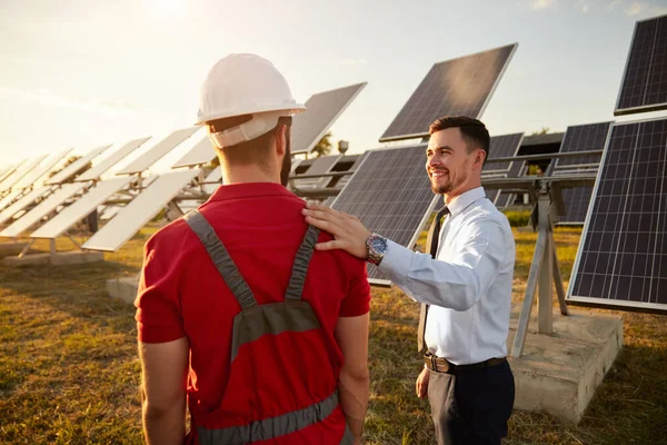 Uomo d'affari e ingegnere in campo con batterie solari — Foto Stock