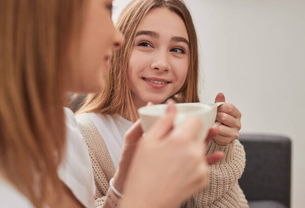 Mother and daughter drinking coffee at home