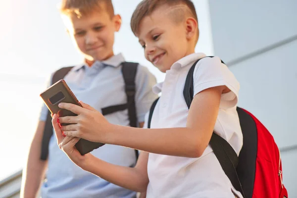 Écoliers utilisant un smartphone dans la rue — Photo