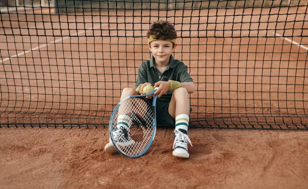 Chlapec s tenisovou raketou a míčem na hřišti — Stock fotografie