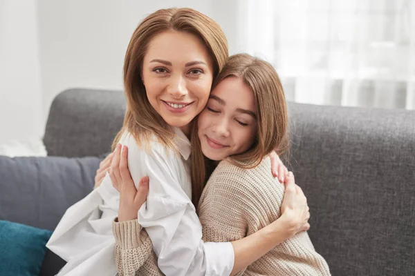 Mãe e filha abraçando em casa — Fotografia de Stock