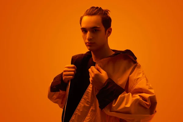 Moda adolescente ajustando chaqueta bajo luz naranja neón —  Fotos de Stock