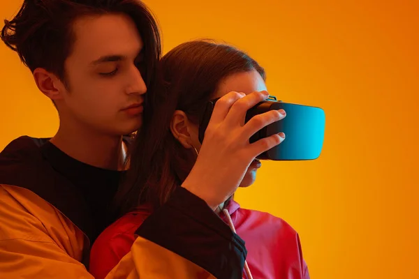 青少年夫妇用霓虹灯在工作室里探索虚拟现实 — 图库照片