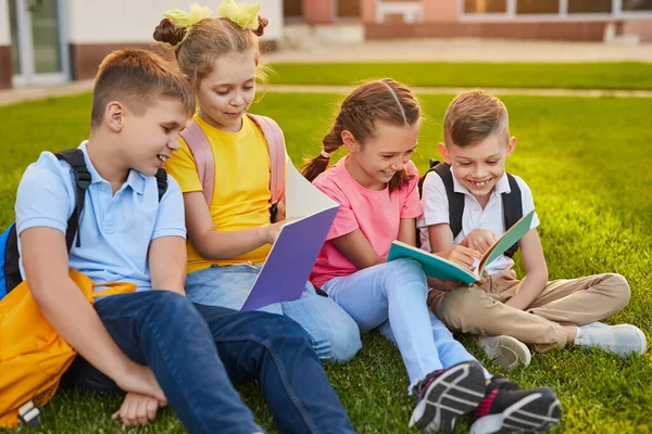 Schoolkinderen die samen huiswerk maken op het schoolplein — Stockfoto