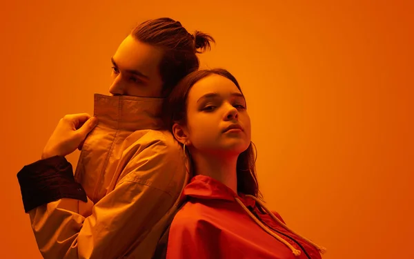 Pasangan keren di studio dengan cahaya oranye — Stok Foto