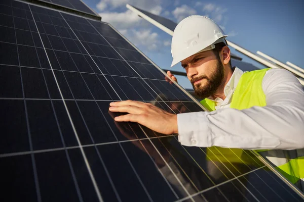 Ingegnere in uniforme esaminando pannello di energia solare — Foto Stock