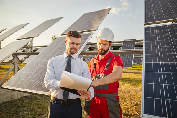 Entreprenör läser papper med entreprenör i solkraftverk — Stockfoto
