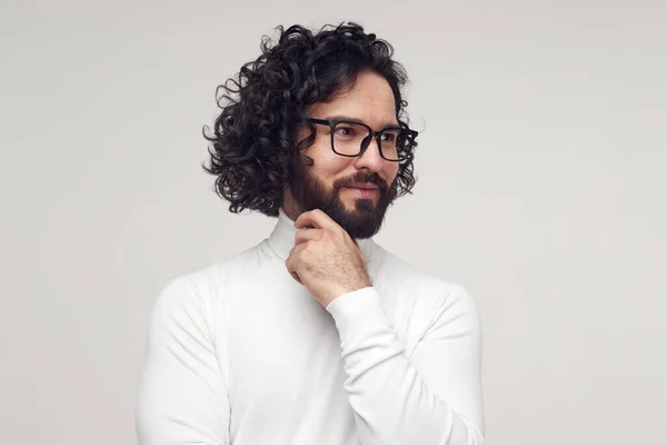 Hombre inteligente en gafas tocando la barbilla en el estudio — Foto de Stock