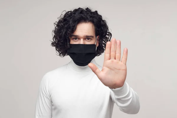 Чоловік у масці для жестів стоп для підтримки соціальної дистанції — стокове фото