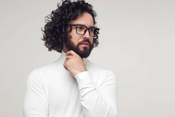 Pensive vousatý muž v brýlích dotýkající se brady ve studiu — Stock fotografie