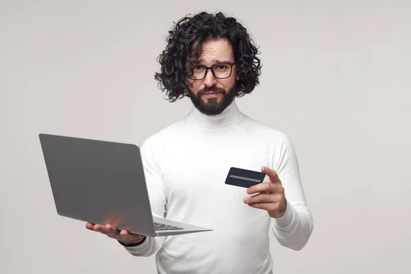 Bilgisayarda kredi kartıyla online alışveriş yapan kafası karışmış bir adam. — Stok fotoğraf
