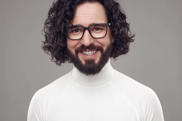 Szczęśliwy kręcone włosy brodaty mężczyzna w okulary w studio — Zdjęcie stockowe