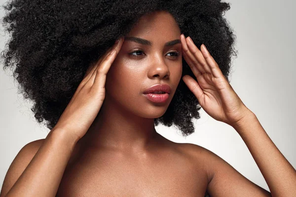 Locka unga afroamerikanska dam röra ansiktet och titta bort — Stockfoto