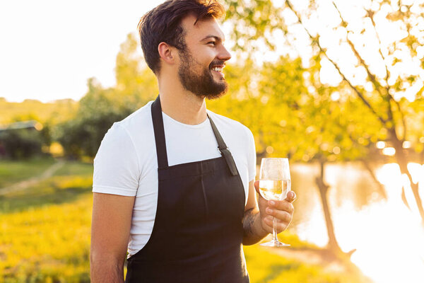 Cheerful Bearded Man White Shirt Black Apron Enjoying Wine Looking Royalty Free Stock Photos