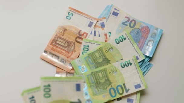 男性の手は白いテーブルの上に複数のユーロ紙幣を数える 現金の山のスローモーションビデオ — ストック動画