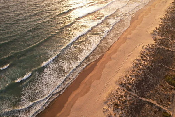 Beautiful Atlantic ocean view over sandy beach and waves at sunset, Portugal. Drone shot of coastline landscape
