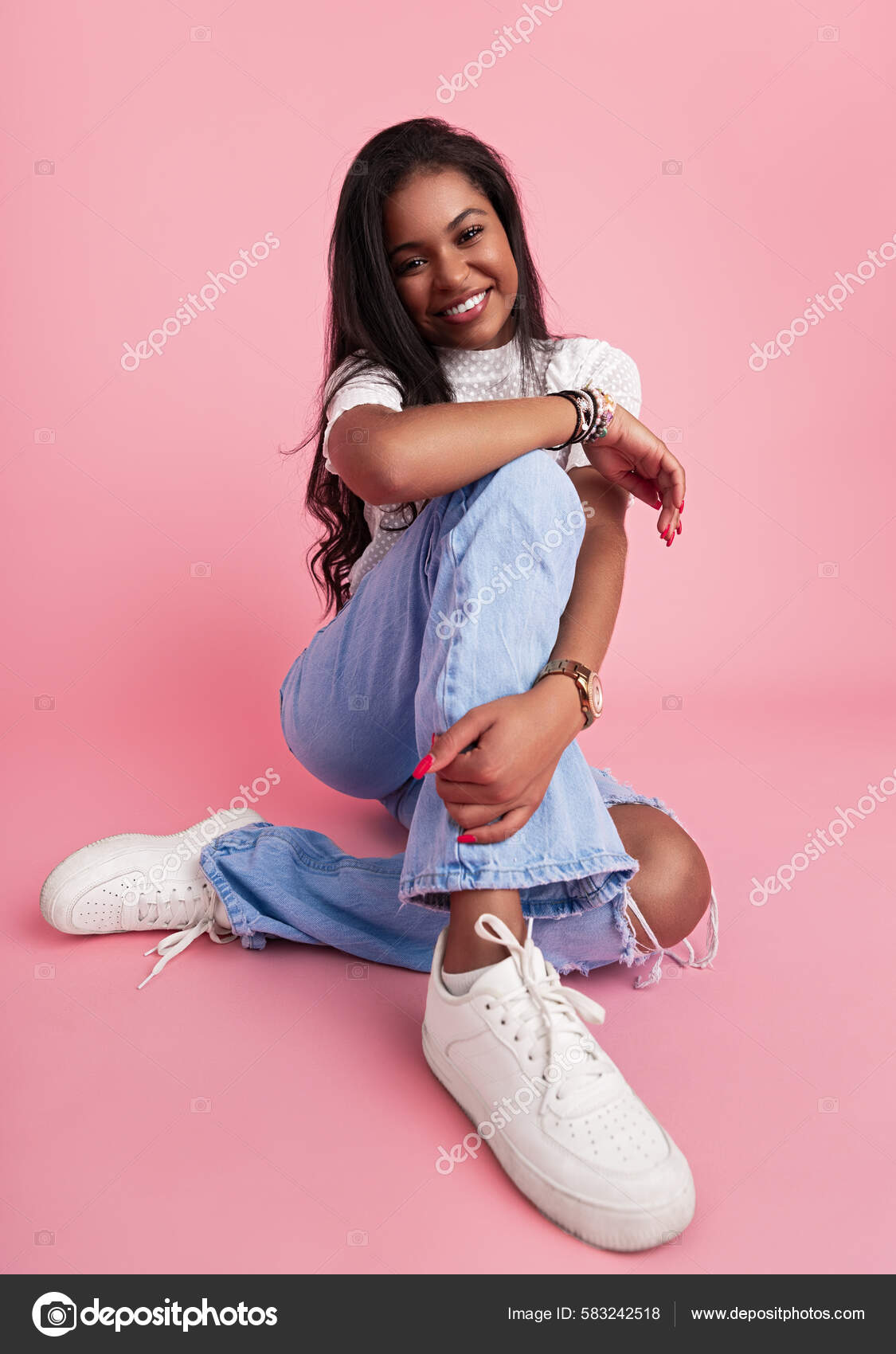 Joven Hispana Alegre Jeans Blusa Con Zapatillas Blancas Tocando Pierna Foto de stock 583242518 kegfire