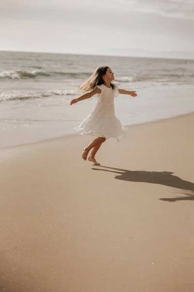 Happy Little Girl White Dress Spreading Arms Spinning While Having — Stok Foto