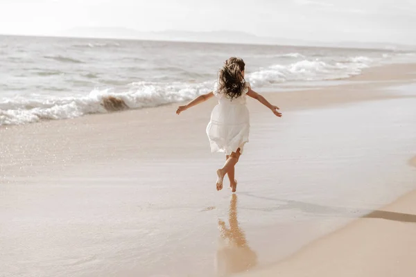 Anonymous Barefoot Child White Dress Spreading Arms Running Wet Sand — 스톡 사진