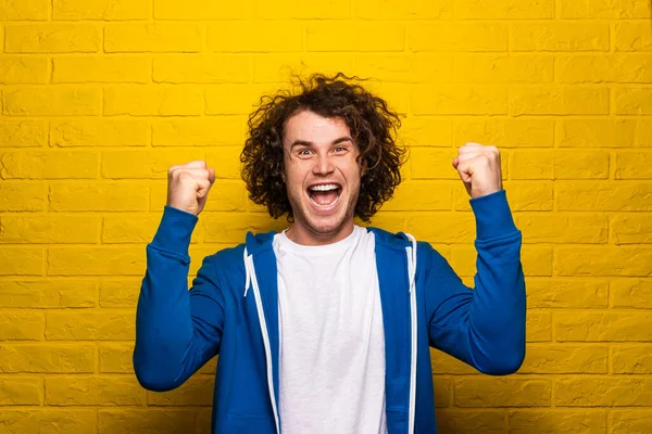 Delighted Young Man Dark Curly Hair Clenched Fists Screaming Loudly — Stockfoto