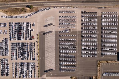 Yepyeni arabaları olan bir fabrikanın büyük otoparkının havadan görünüşü. otomobil endüstrisi kavramının lojistik ve ulaşımı.