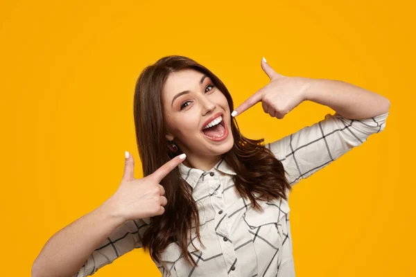 Vrolijk Jong Vrouwelijk Model Met Lang Bruin Shirt Haar Wijzend — Stockfoto