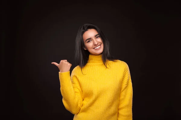 Cheerful Hispanic Female Yellow Sweater Looking Camera Smile Pointing Away — Stockfoto