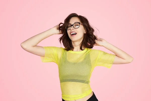 Glad Young Woman Stylish Clothes Glasses Touching Hair Looking Camera — Foto de Stock