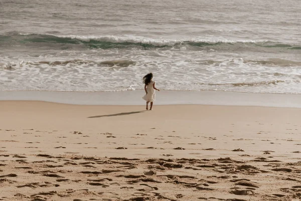 Girl White Dress Strolling Sandy Beach Waving Sea Stormy Day — Stockfoto