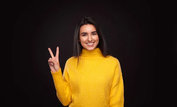 Happy Woman Yellow Sweater Looking Camera Smile Showing Two Fingers — Stockfoto