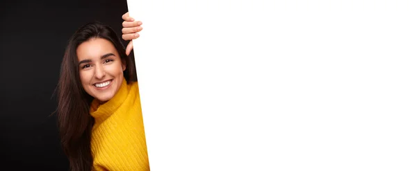 Cheerful Young Hispanic Woman Yellow Sweater Smiling Peeking Blank Placard — ストック写真