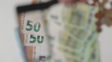 Man checking 100 euro with magnifying glass. Close-up checking counterfeit money under zoom lens