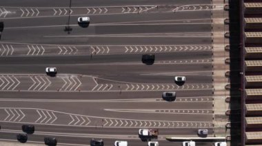 Aerial view timelapse of highway toll collection point with multiple cars on lanes paying and exiting booths.