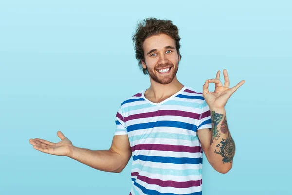 Cheerful Young Male Striped Shirt Tattooed Arm Gesturing Okay Looking — Stockfoto