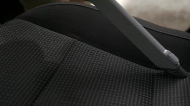Closeup footage of cleaning car seat with vacuum cleaner. Car interior washing service with cordless modern vacuuming equipment.