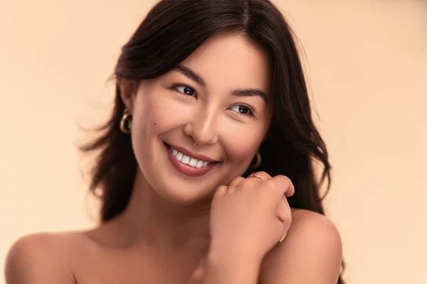 Młoda Azjatka Czystą Twarzą Pięknymi Włosami Uśmiechnięta Beżowym Tle — Zdjęcie stockowe
